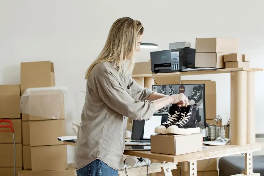Empreendedor embalando um tênis para envio